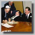 The men around the round table doin' bizness. Harry Hermann signing away.